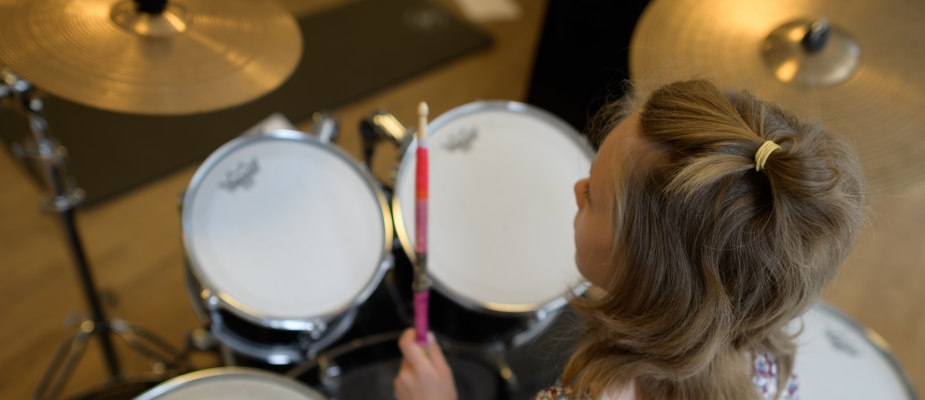 Fragment zdjęcia - dziewczynka grająca na perkusji